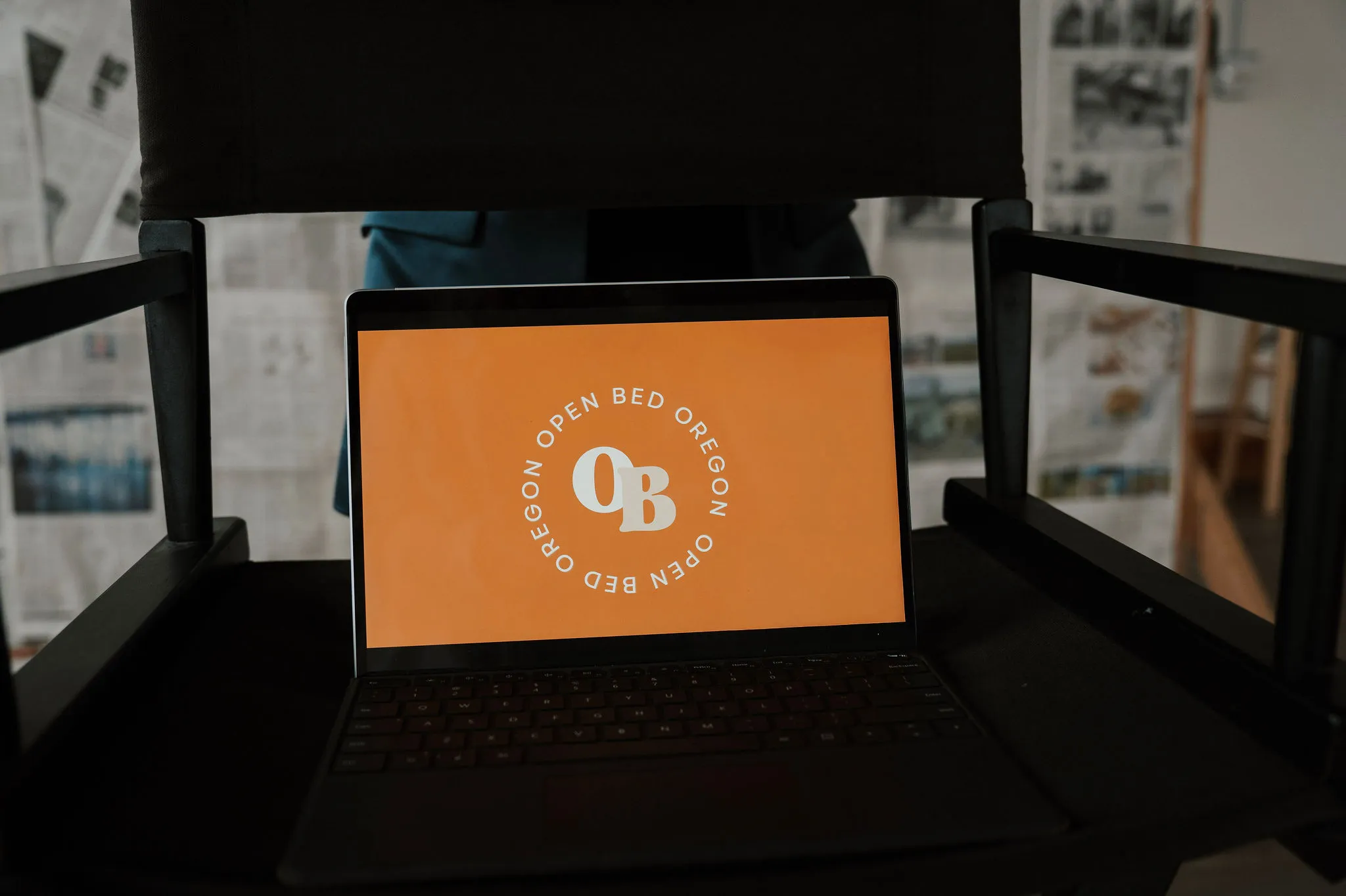 A laptop open on a chair.